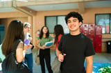 Happy high school exchange student smiling in a school hallway