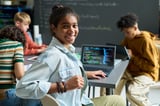 Teenage exchange student smiling at a desk with an open laptop