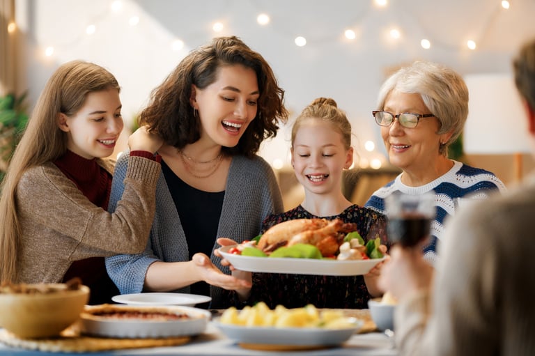 Happy family sitting around the table celebrating Thanksgiving dinner together
