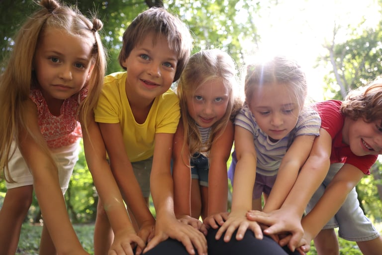 Cute little kids having fun together in park, low angle view