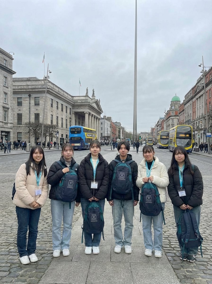 Group of six young people wearing lanyards standing in an urban plaza with historic buildings, buses, and a tall monument in the background